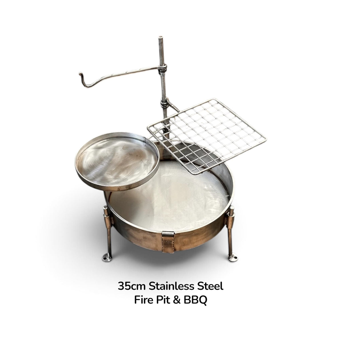 35cm Stainless Steel Fire Pit & BBQ Cook Station – complete setup showing stainless fire pit bowl with grill plate, skillet pan and hook arm, TJM Metalworks